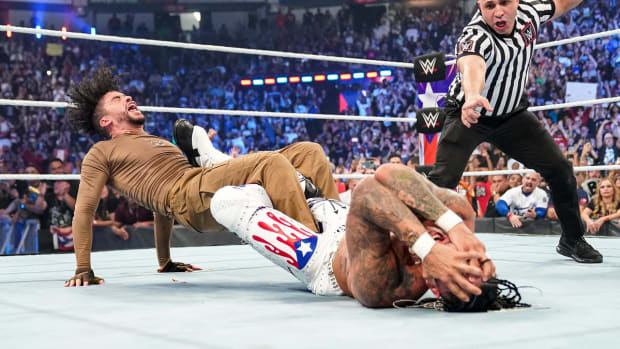 Bad Bunny and Damian Priest in a figure-four leg lock